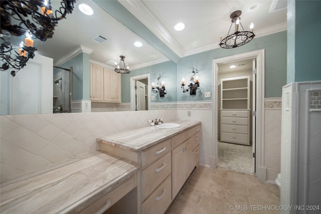 bathroom featuring vanity, a chandelier, tile walls, crown molding, and a shower with door