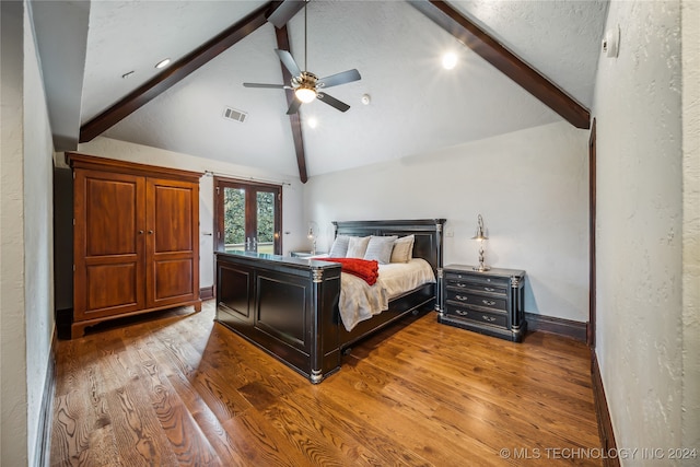 bedroom featuring wood-type flooring, a textured ceiling, vaulted ceiling with beams, ceiling fan, and french doors