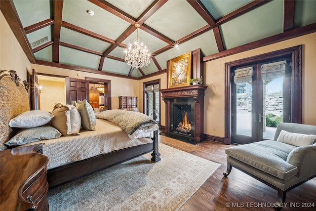 bedroom with wood-type flooring, a notable chandelier, beam ceiling, coffered ceiling, and access to outside