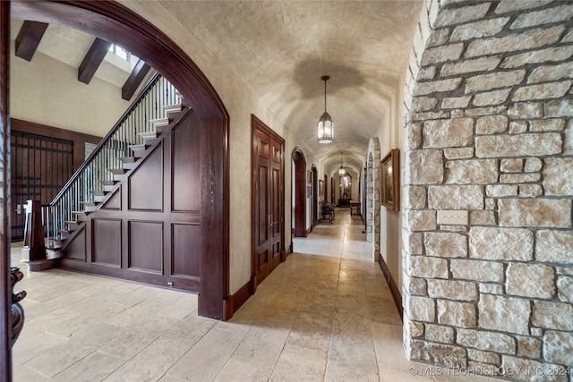 hallway featuring lofted ceiling with beams