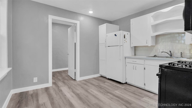 kitchen featuring white refrigerator, sink, white cabinetry, black range with electric cooktop, and light hardwood / wood-style floors