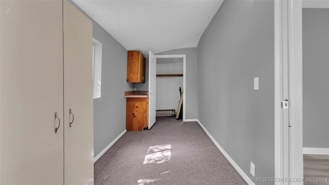 hallway featuring vaulted ceiling and light carpet