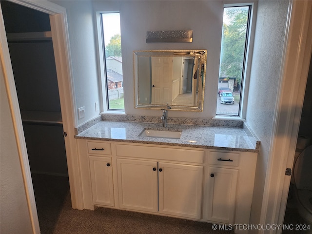 bathroom featuring a healthy amount of sunlight, vanity, and toilet