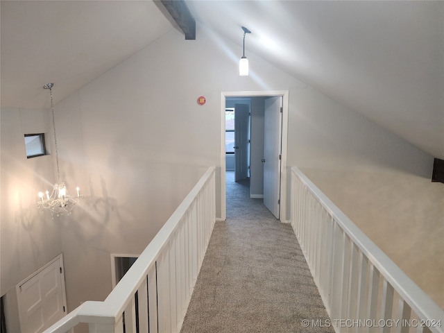 hall with vaulted ceiling with beams, an inviting chandelier, and light colored carpet