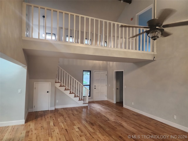 unfurnished living room with high vaulted ceiling, ceiling fan, and hardwood / wood-style floors