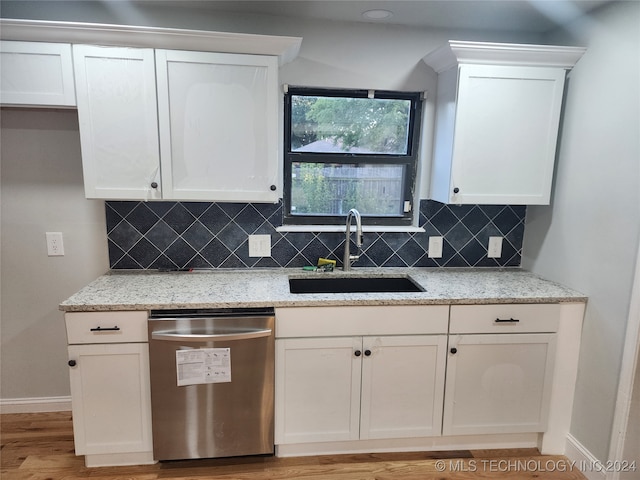 kitchen featuring light wood-type flooring, light stone counters, tasteful backsplash, sink, and stainless steel dishwasher