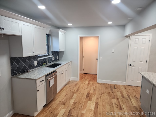 kitchen featuring white cabinets, light stone countertops, sink, and stainless steel dishwasher