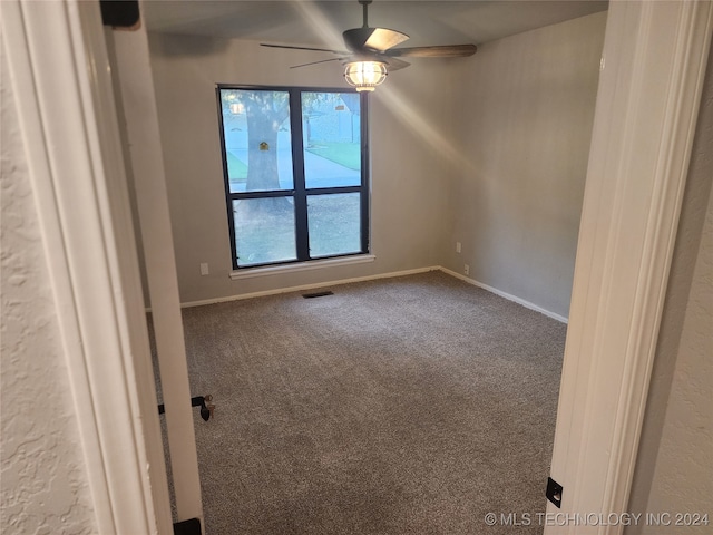 unfurnished room featuring ceiling fan and carpet flooring