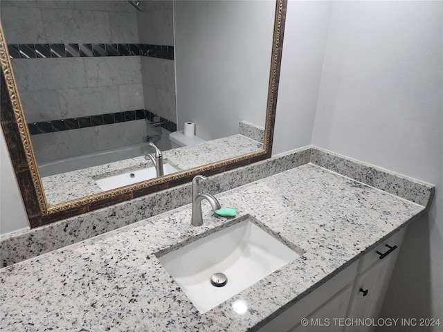 bathroom featuring vanity, a bathtub, and toilet