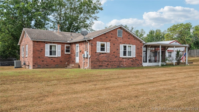 back of house with central AC unit and a lawn