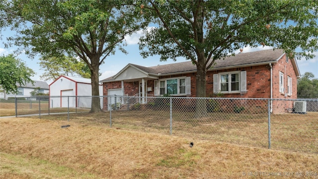 view of front facade featuring central AC, an outbuilding, a front yard, and a garage