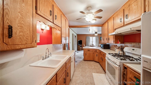 kitchen with kitchen peninsula, ceiling fan, white appliances, and sink