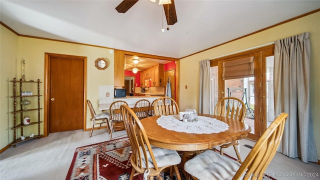 dining area featuring light carpet, ceiling fan, and ornamental molding