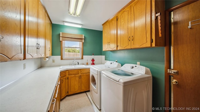 washroom featuring cabinets, washer and clothes dryer, and sink