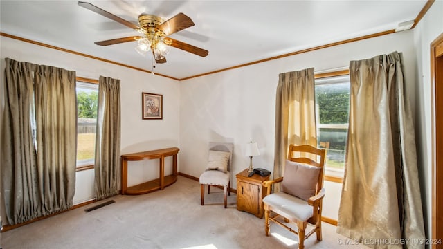 living area with light carpet, ceiling fan, and ornamental molding