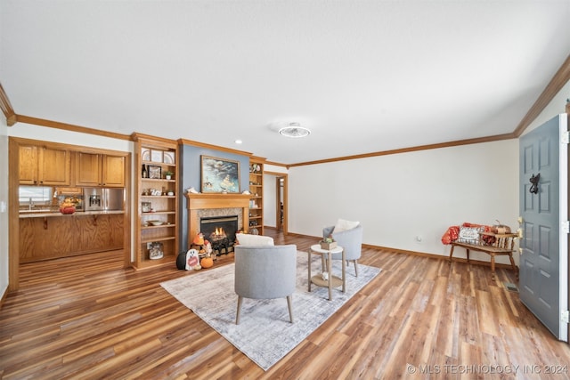 living room with light hardwood / wood-style floors, sink, and crown molding