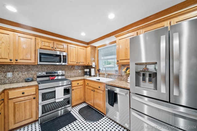 kitchen with appliances with stainless steel finishes, decorative backsplash, light stone counters, ornamental molding, and sink