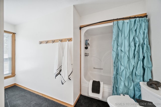 bathroom with shower / tub combo with curtain, toilet, and a wealth of natural light