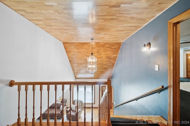 stairway with wooden ceiling, vaulted ceiling, and a notable chandelier