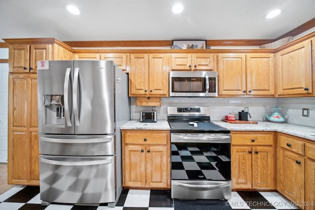 kitchen with light stone counters, appliances with stainless steel finishes, and tasteful backsplash