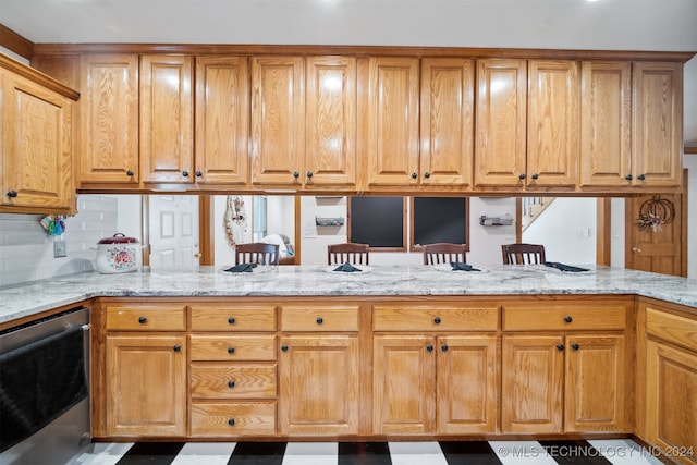 kitchen featuring stainless steel dishwasher, kitchen peninsula, light stone countertops, and tasteful backsplash