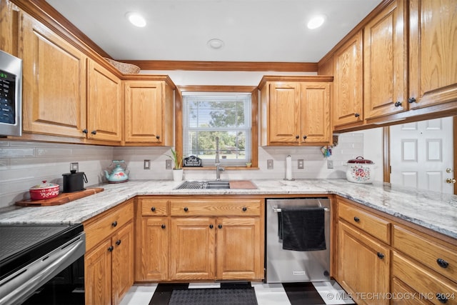 kitchen featuring appliances with stainless steel finishes, light stone countertops, sink, and decorative backsplash