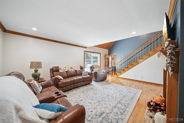 living room featuring lofted ceiling, light hardwood / wood-style floors, crown molding, and a textured ceiling