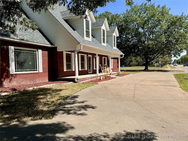 view of side of home with a lawn and covered porch