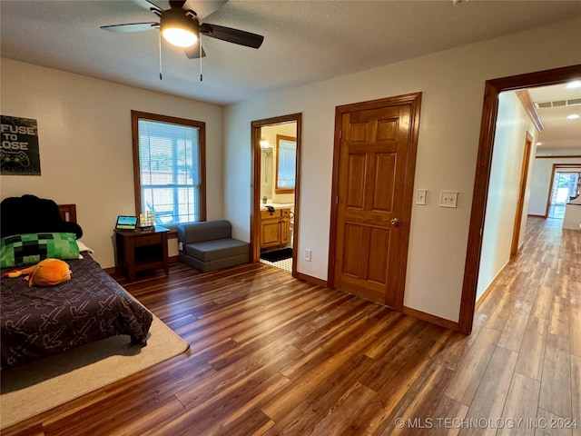 bedroom featuring ceiling fan, a textured ceiling, dark hardwood / wood-style floors, and ensuite bathroom