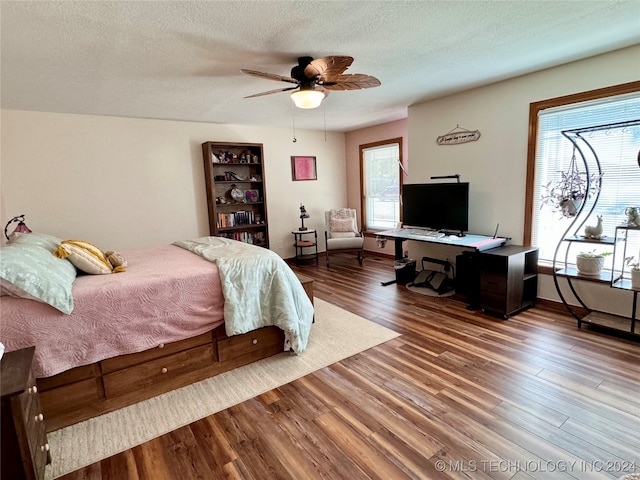 bedroom featuring wood-type flooring, ceiling fan, and a textured ceiling