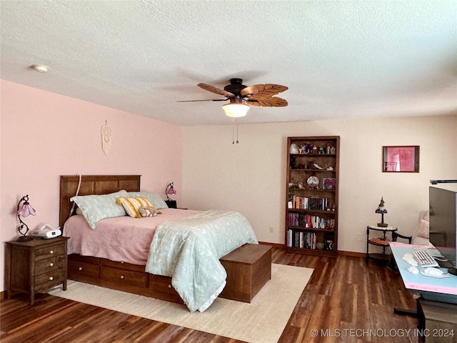 bedroom with a textured ceiling, dark hardwood / wood-style floors, and ceiling fan