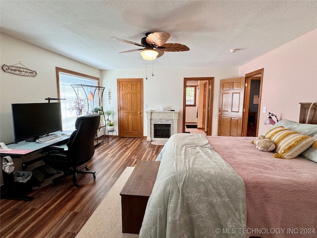 bedroom with wood-type flooring, multiple windows, ceiling fan, and a textured ceiling