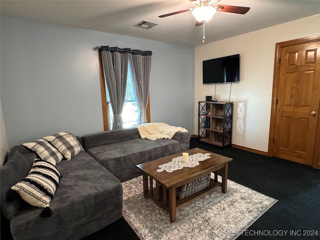 living room featuring ceiling fan, a textured ceiling, and dark carpet