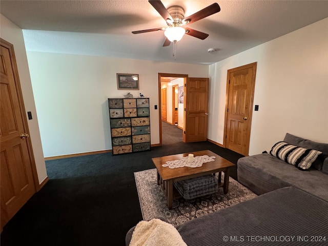 living room featuring dark colored carpet, ceiling fan, and a textured ceiling