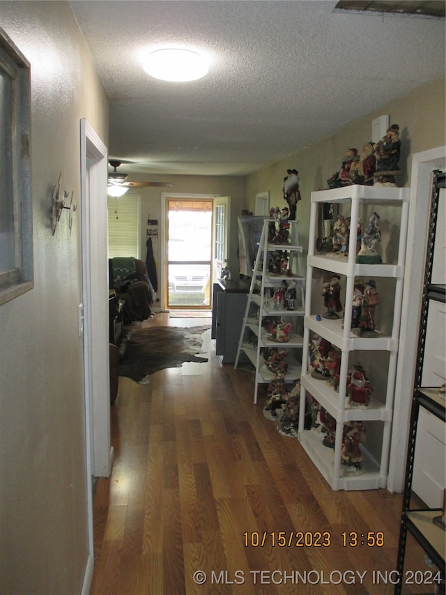 hallway featuring a textured ceiling and dark hardwood / wood-style flooring