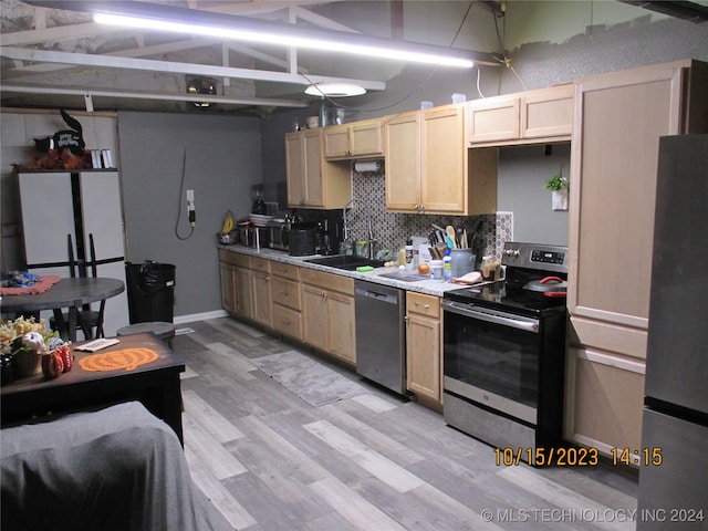 kitchen featuring light brown cabinets, sink, appliances with stainless steel finishes, light hardwood / wood-style floors, and decorative backsplash