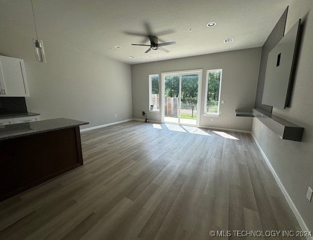 unfurnished living room featuring light hardwood / wood-style floors and ceiling fan