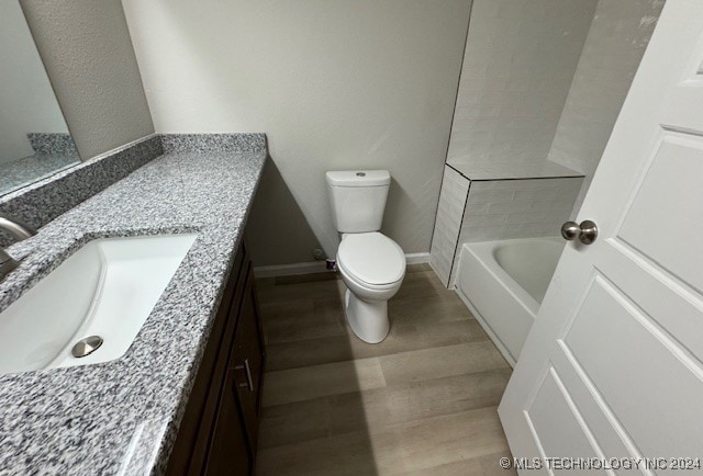 full bathroom with independent shower and bath, vanity, hardwood / wood-style floors, and toilet