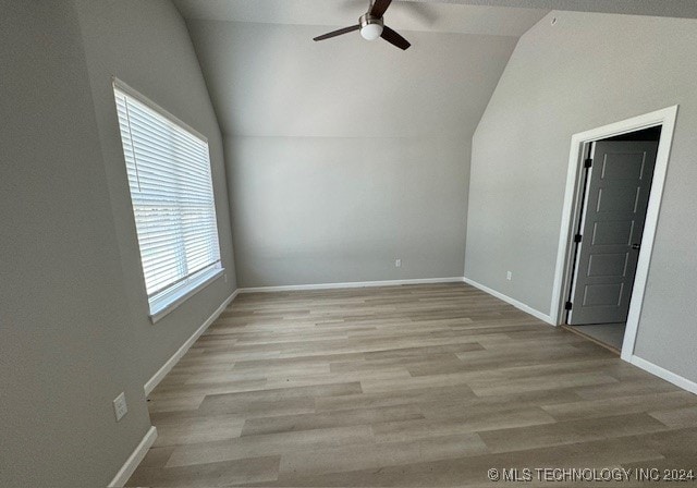 empty room featuring light hardwood / wood-style floors, lofted ceiling, and ceiling fan