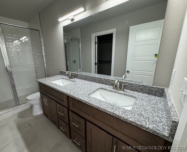 bathroom with a shower with door, toilet, and vanity