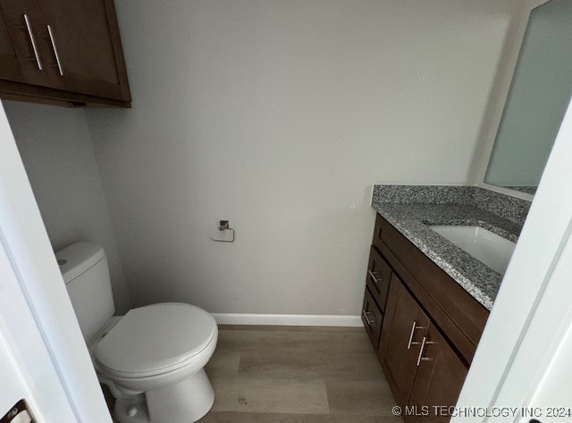 bathroom with hardwood / wood-style flooring, vanity, and toilet