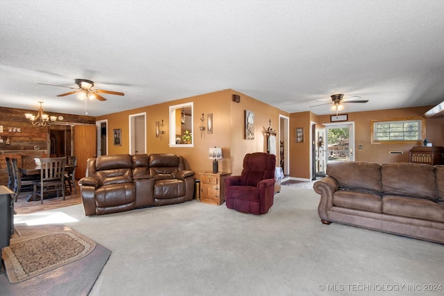 carpeted living room with ceiling fan with notable chandelier and a textured ceiling