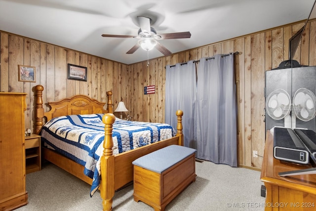 carpeted bedroom with wooden walls and ceiling fan