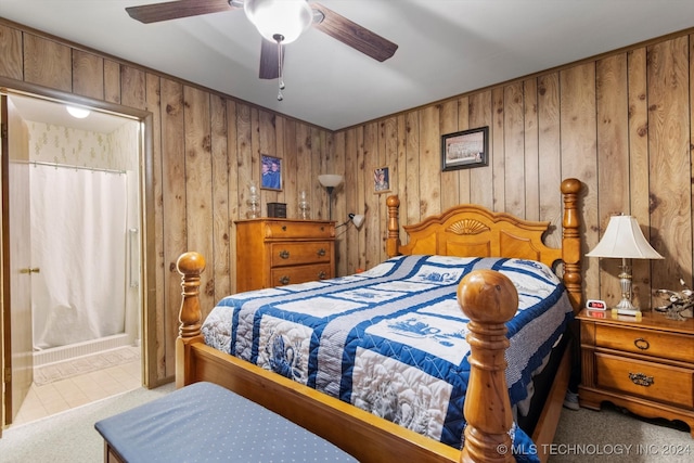 carpeted bedroom featuring wooden walls and ceiling fan