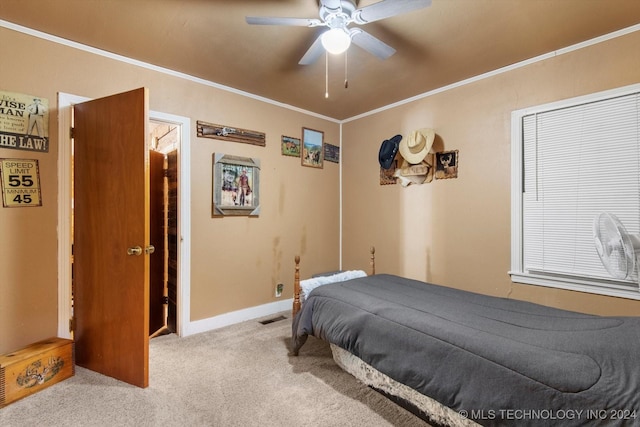 carpeted bedroom with ornamental molding and ceiling fan