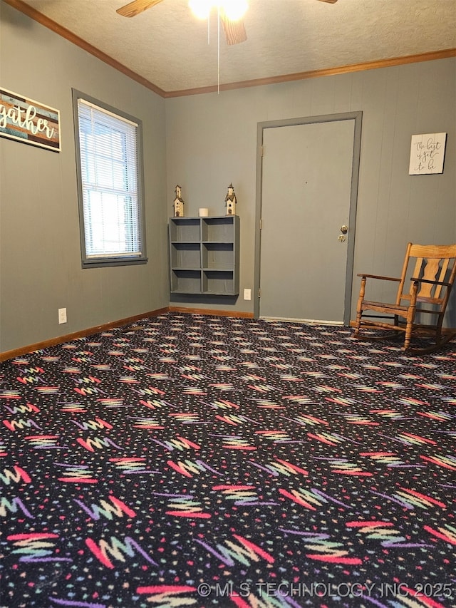 spare room featuring ceiling fan, ornamental molding, carpet flooring, and a textured ceiling