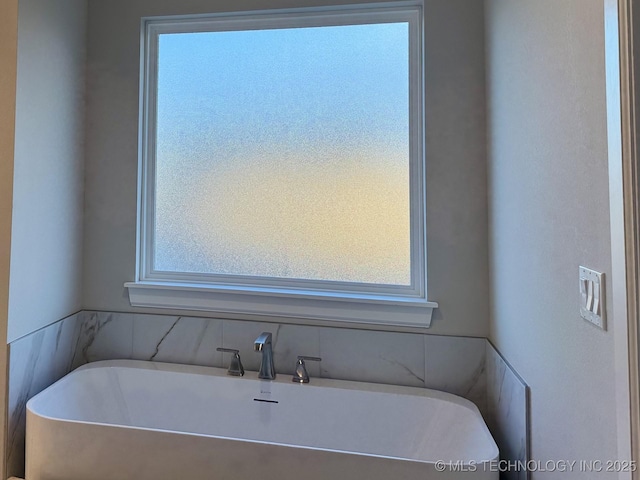 full bathroom with a soaking tub and a wealth of natural light