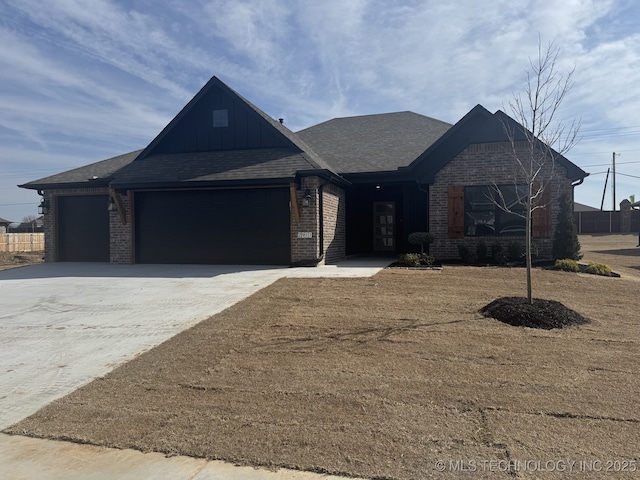 single story home with concrete driveway, roof with shingles, an attached garage, board and batten siding, and brick siding