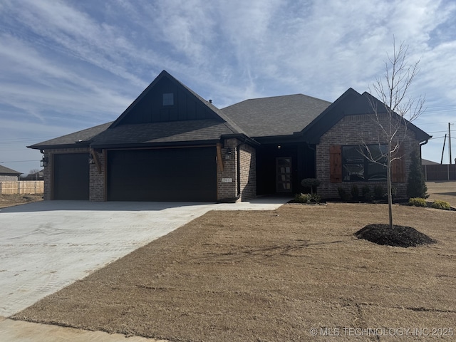 view of front of home with a garage, brick siding, and board and batten siding