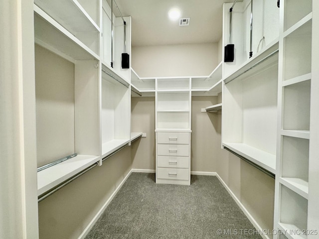 walk in closet featuring visible vents and dark carpet